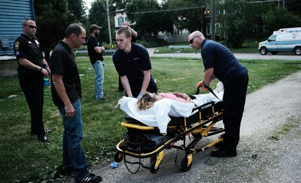 Medical workers and police treat a woman who has overdosed on heroin, the second case in a matter of minutes in Warren, Ohio
