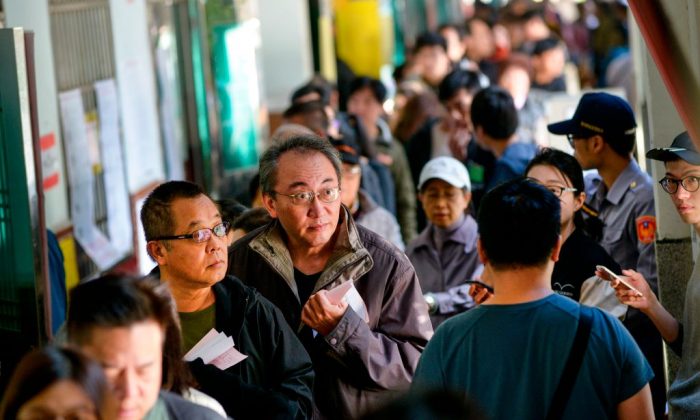 2018 年 11 月 24 日，居民在一所小学的投票站外排队参加台北地方选举。（Chris Stowers/AFP/Getty Images）