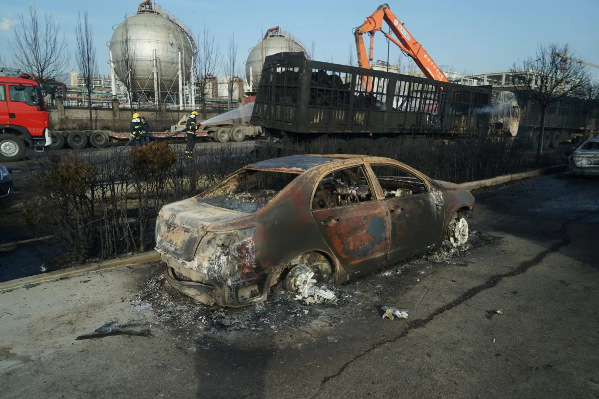 Firefighters work next to burnt trucks and car following a blast near the Shenghua chemical plant in Zhangjiakou, Hebei Province, China on Nov. 28, 2018. (Reuters)