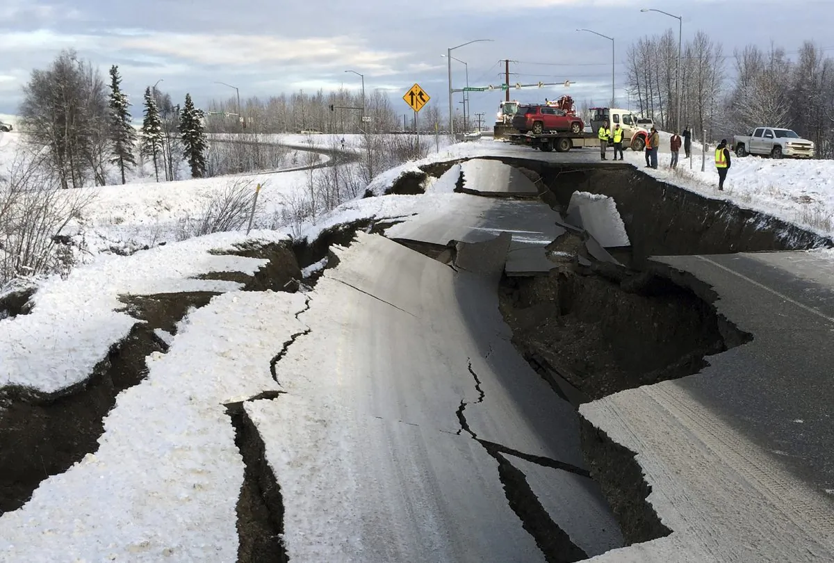 A tow truck holds a car that was pulled from on an off-ramp that collapsed during a morning earthquake in Anchorage, Alaska, on Nov. 30, 2018. (Mike Dinneen/AP)