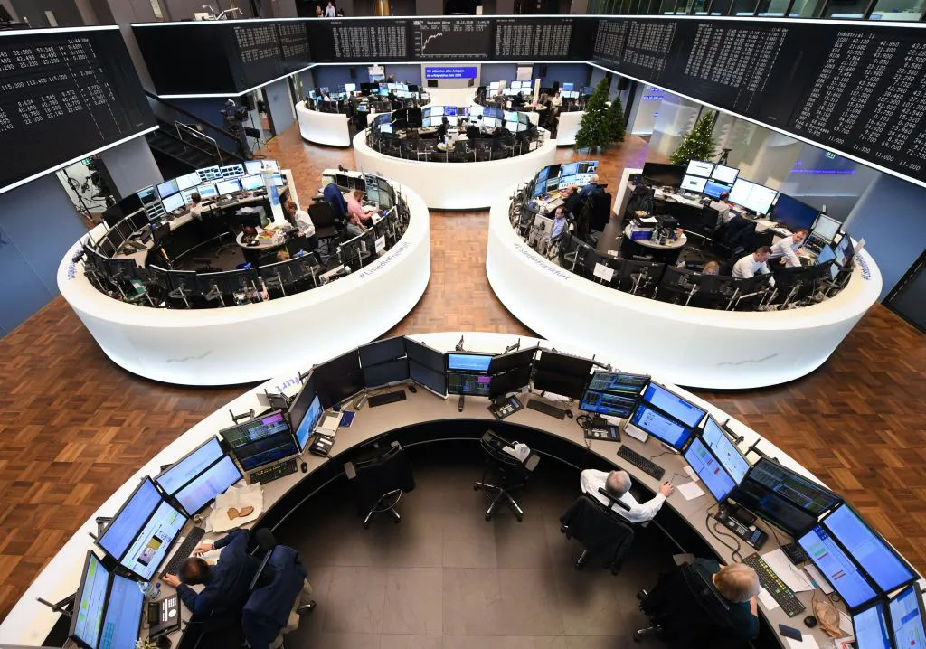 Traders work in front of a board displaying the chart of Germany's share index DAX (background) at the stock exchange in Frankfurt am Main, western Germany, on Dec. 28, 2018. (Arne Dedert/AFP/Getty Images)