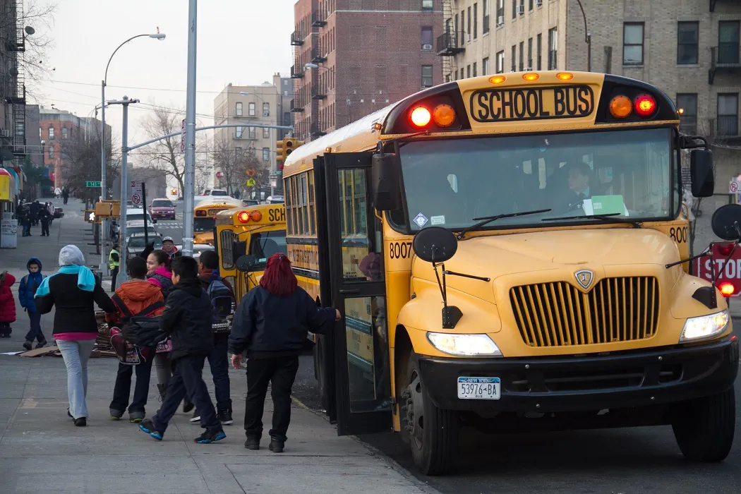 Students exit a school bus in front of their school in the Bronx, New York City, on Jan. 9, 2013. (Benjamin Chasteen/The Epoch Times)
