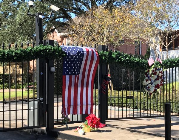 A flag is draped over the gate to the neighborhood of the home of former President George H.W. Bush