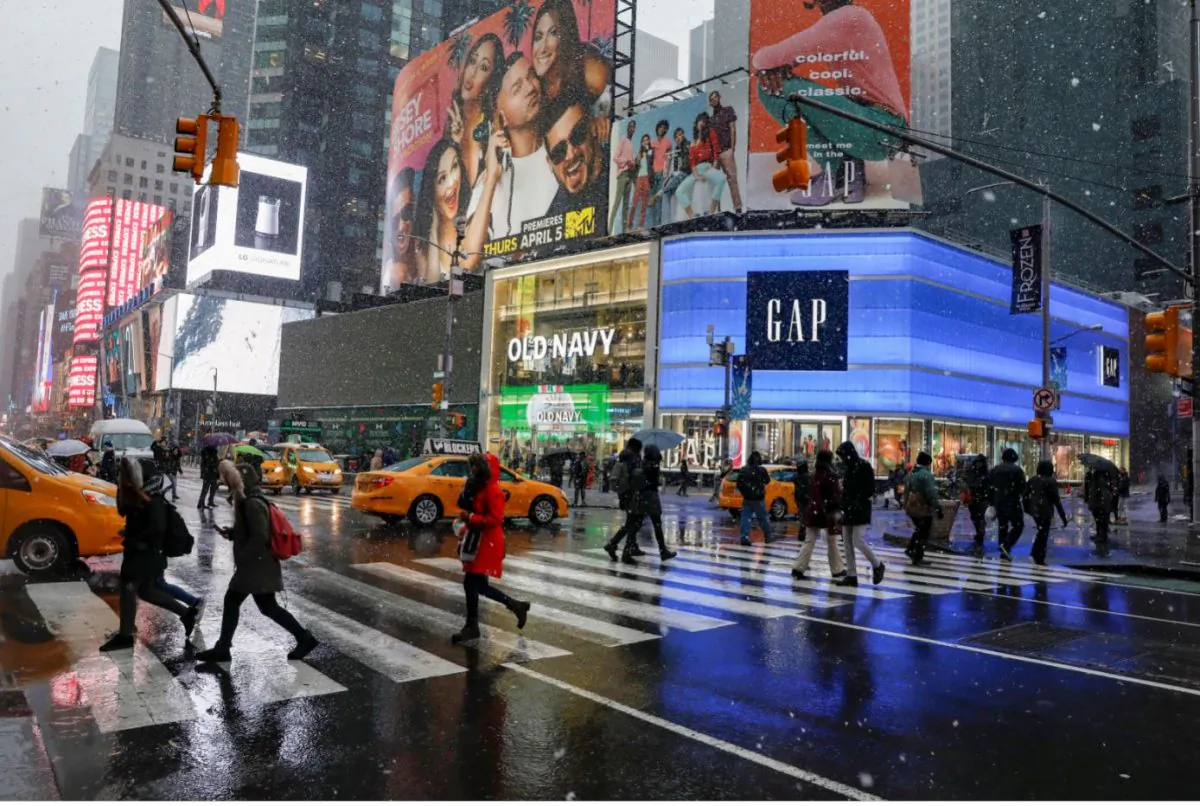 People walk through the snow during a winter nor'easter storm in Times Square in New York City, U.S., Mar. 21, 2018.