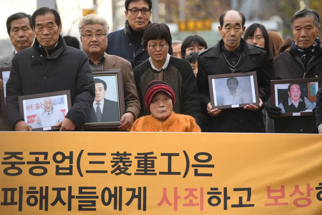 Kim Sung-joo (bottom C), a victim of forced labor by Japan during its colonial rule of the Korean peninsula from 1910 to 1945, and relatives of other victims arrive at the Supreme Court in Seoul on Nov. 29, 2018. South Korea's top court on Nov. 29 ordered a Japanese heavy industries giant to pay compensation over forced wartime labor, despite a previous 1965 settlement. (JUNG YEON-JE/AFP/Getty Images)