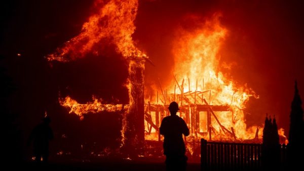 Home burns while a person watches
