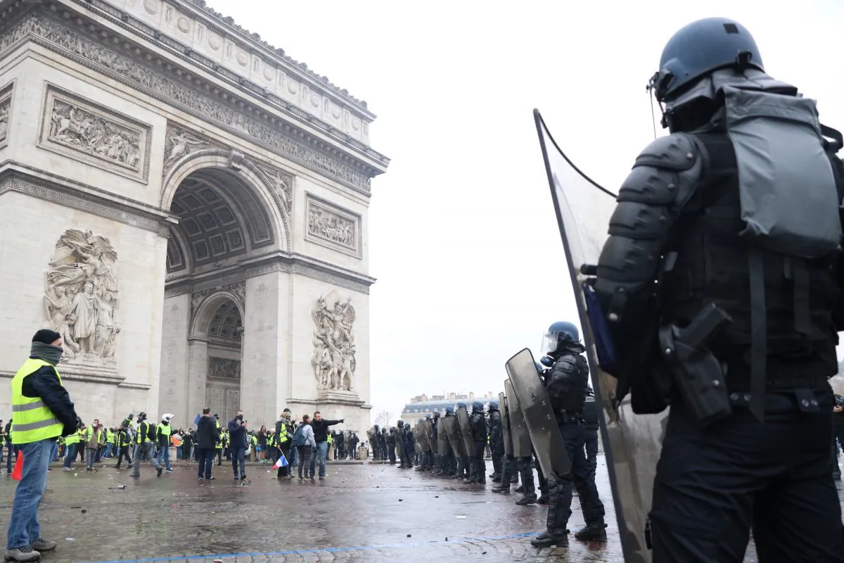 Riot police line up in front of Yellow vest protesters in Place de  l'Etoile in Paris on Dec. 1, 2018. (David Vives/The Epoch Times)