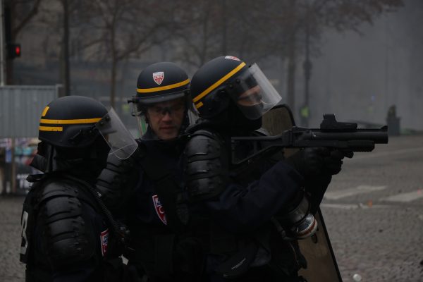 Riot police stand ready to launch grenade gas on Kleber Avenue in Paris.
