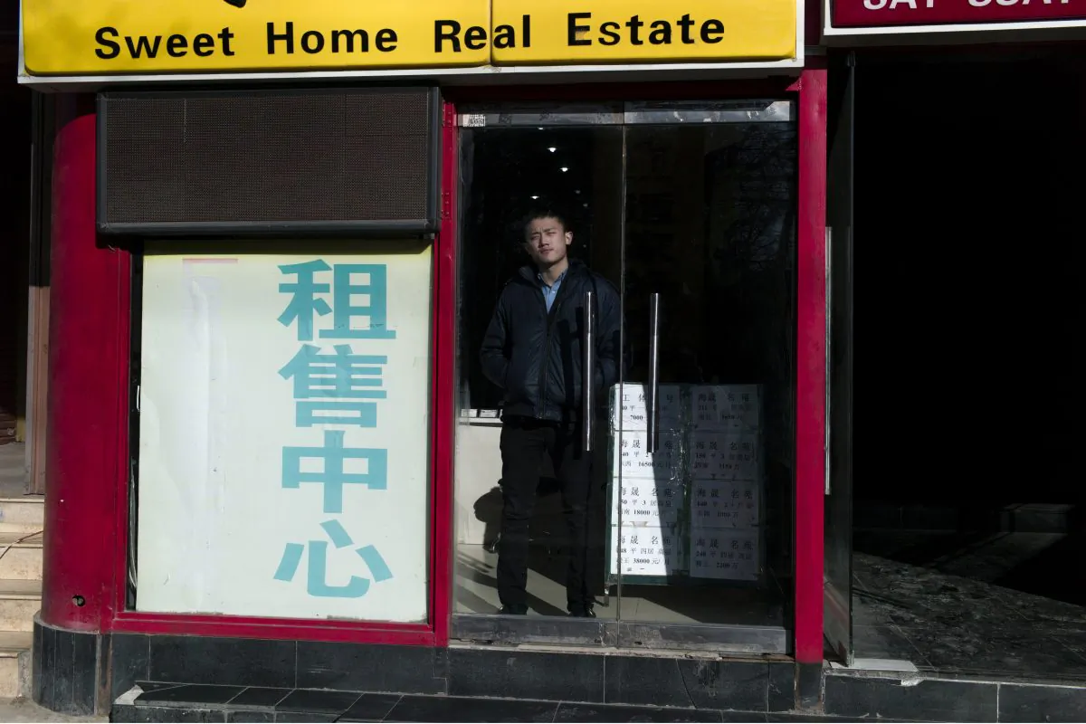 A real estate agent waits for customers inside his office in Beijing on Jan, 17, 2016. (Fred Dufour/AFP/Getty Images)
