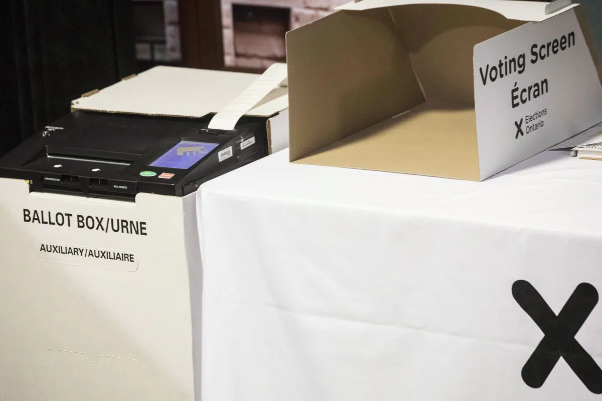 A vote tabulator (L) sits next to a voting screen in Toronto, on May 9, 2018. (The Canadian Press/Chris Young)