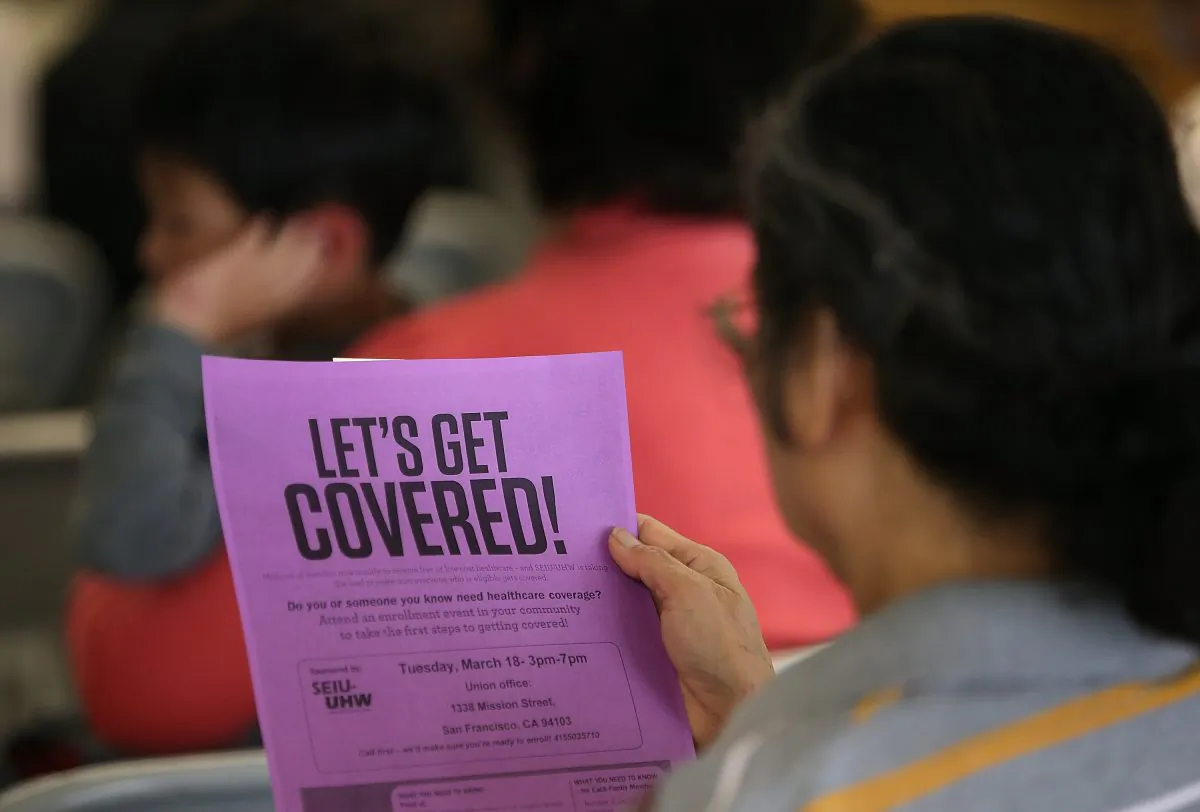 An attendee reads a flyer during a healthcare enrollment fair at the office of SEIU-United Healthcare Workers West in San Francisco on March 18, 2014. (Justin Sullivan/Getty Images)