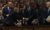 Video: George W. Bush Appears to Give Michelle Obama Candy During Funeral