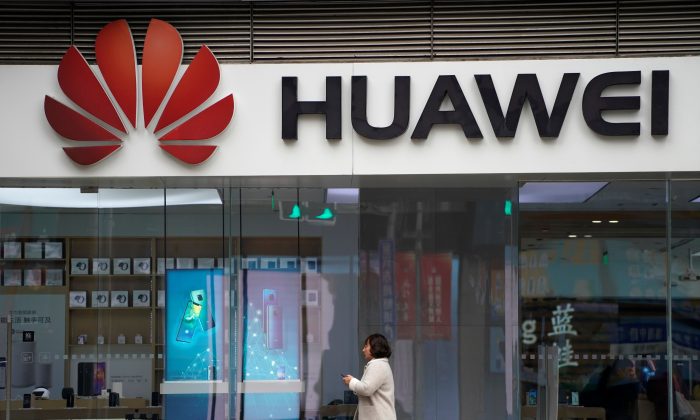 A woman walks by a Huawei logo at a shopping mall in Shanghai, China, on Dec. 6, 2018. (Aly Song/Reuters)