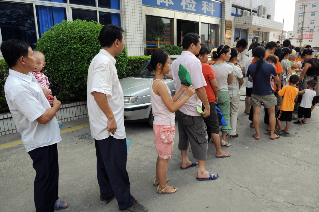 Parents accompanying their children for a check-up queue up in front of Longgang central hospital in Shenzhen, Guangdong Province on Sept. 21, 2008. (Ted Aljibe/AFP/Getty Images)