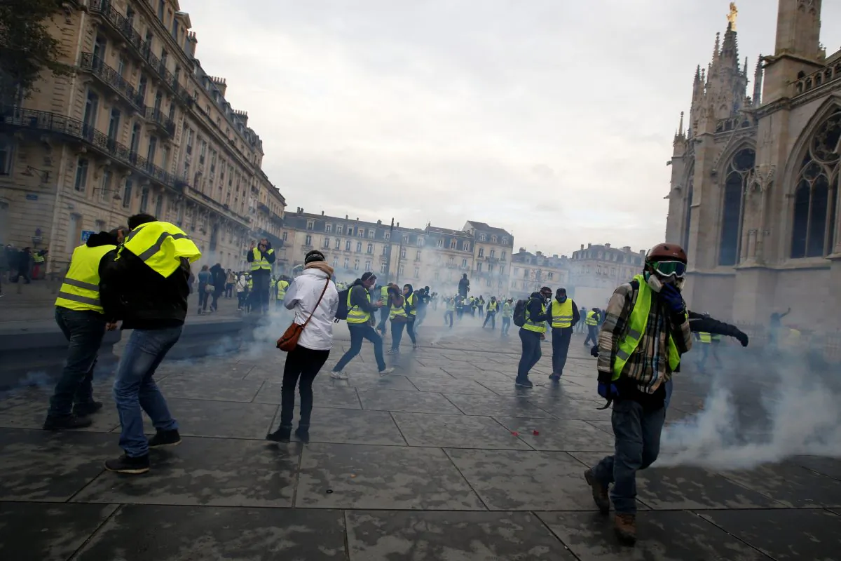 Protesters wearing yellow vests walk through tear gas during clashes with police at a demonstration of the "yellow vests" movement in Bordeaux, France, on Dec. 8, 2018. (REUTERS/Regis Duvignau)
