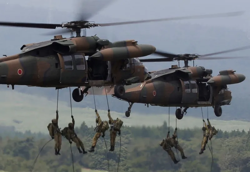 Japanese Ground Self-Defense Force soldiers rappel from UH-60 Black Hawk helicopters during an annual training session near Mount Fuji at Higashifuji training field in Gotemba, west of Tokyo, Japan, on Aug. 24, 2017. (Issei Kato/Reuters)