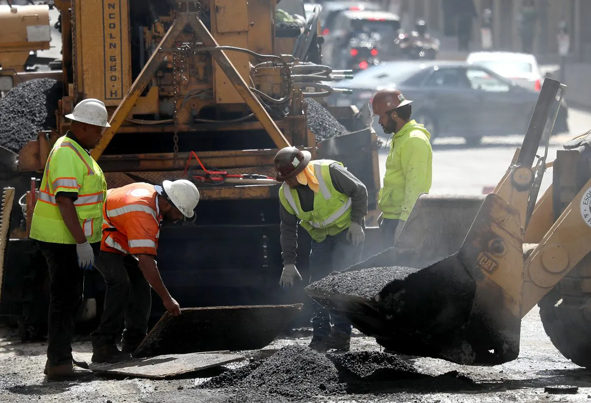 Construction workers smooth tar as they pave a road in San Francisco, Calif., on Oct. 5, 2018. (Justin Sullivan/Getty Images)