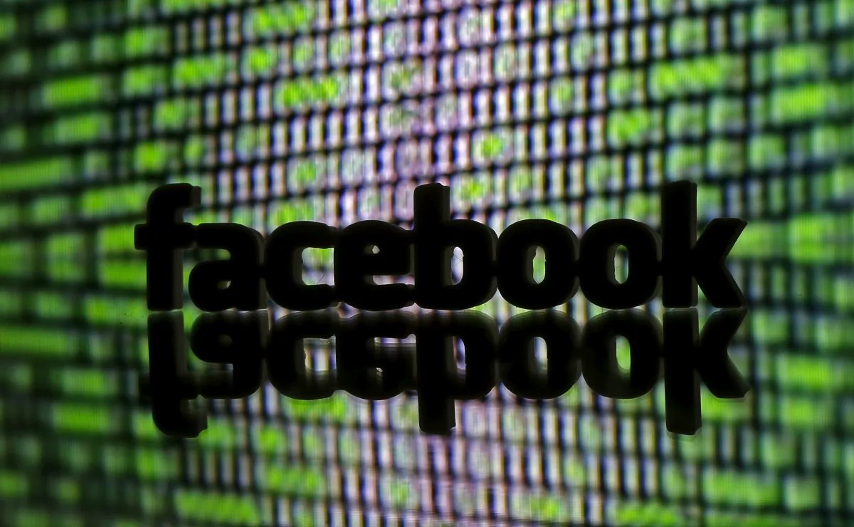 A 3D printed Facebook logo is seen in front of displayed cyber code in this illustration taken March 22, 2016. (Reuters/Dado Ruvic)
