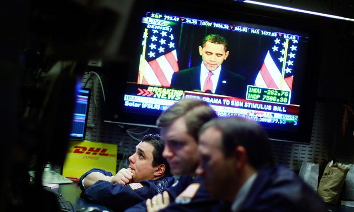 Traders work on the floor of the New York Stock Exchange during afternoon trading as President Barack Obama is seen on television at the economic stimulus bill signing ceremony on Feb. 17, 2009. Despite evidence that stimulus plans do not stimulate the economy, "experts" continue to recommend them. (Mario Tama/Getty Images)