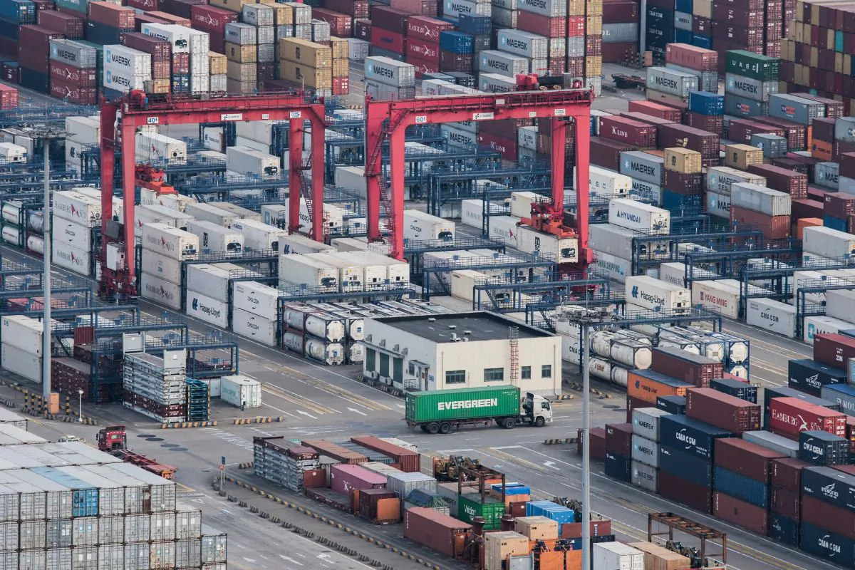 A cargo truck drives amid stacked shipping containers at the Yangshan port in Shanghai, China on March 28, 2018. China's export growth sank in November, 2018, as global demand weakened, adding to pressure on Beijing ahead of trade talks with Washington. (AP)