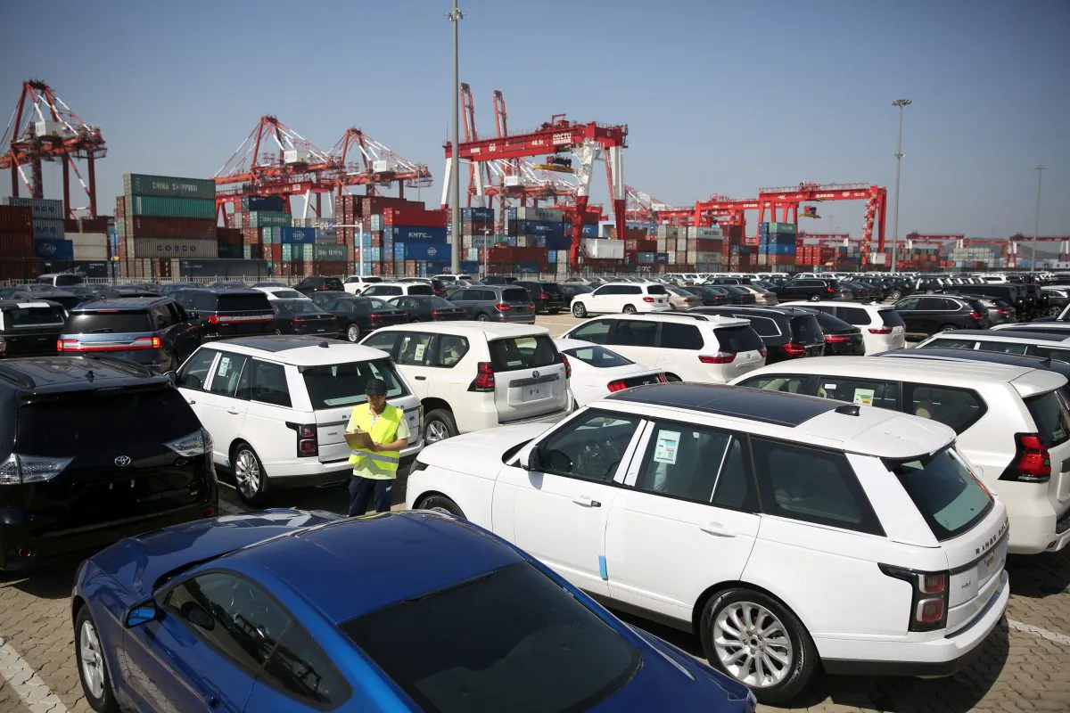 A worker inspects imported cars at a port in Qingdao, Shandong Province, China on May 23, 2018. (Reuters)