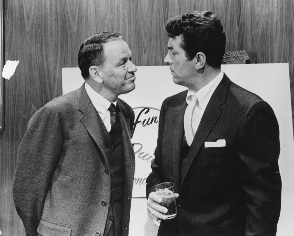 Actor and singer Frank Sinatra with fellow performer Dean Martin during filming. Both singers have performed the song "Baby It's Cold Outside," with Martin's rendition being the most played version. (Keystone Features/Getty Images)