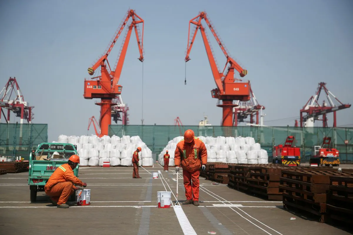 Workers paint the ground at a port in Qingdao, Shandong Province, China  on April 9, 2018. (Reuters)