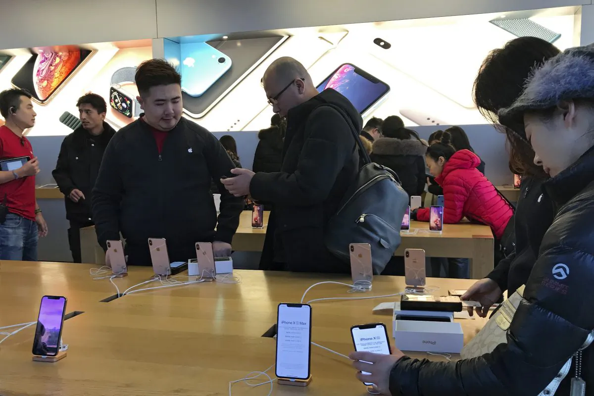 People buy latest iPhone while others try out its latest model at an Apple Store in Beijing on Dec. 11, 2018. China is reportedly planning to ditch its ambitious tech manufacturing domination strategy under "Made in China 2025", as trade talks with the U.S. continue. (AP Photo/Andy Wong)