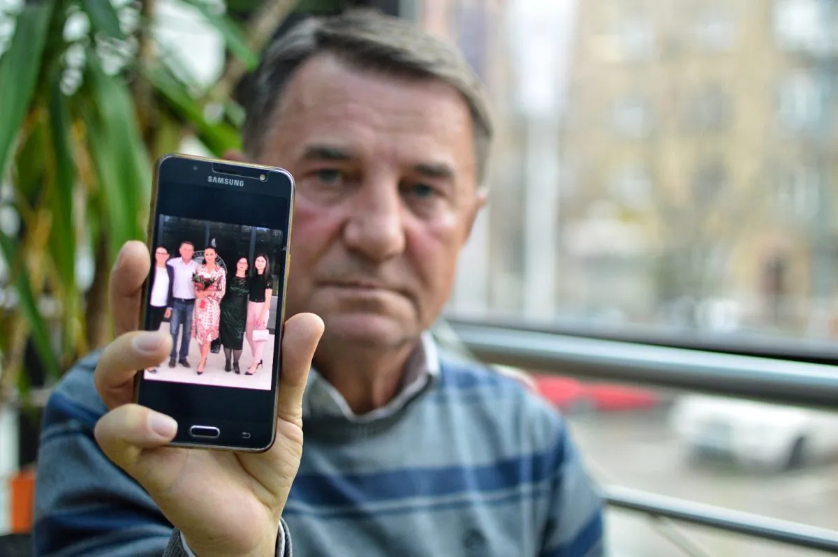 Fikret Grabovica, who lost one of his daughters during the siege of Sarajevo in 1993, shows a photo of his family. (Antonio Cakshiri/Special to The Epoch Times)
