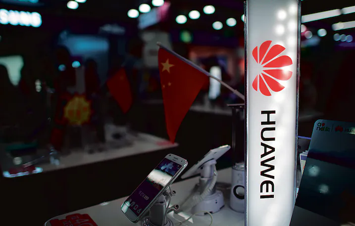 A logo of Huawei next to a Chinese flag in Shanghai on Oct. 1, 2014. (JOHANNES EISELE/AFP/Getty Images)