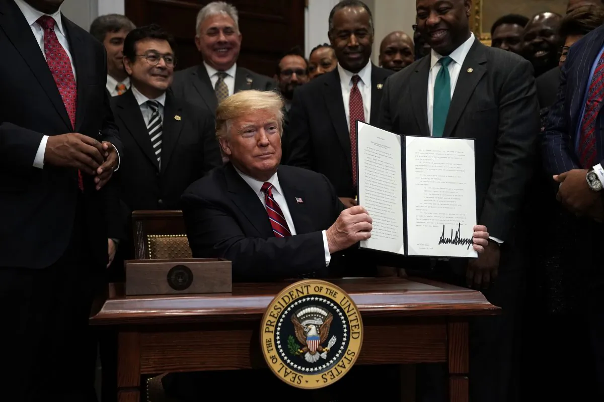 President Donald Trump participates in signing an executive order to establish the White House Opportunity and Revitalization Council as Secretary of Housing and Urban Development Secretary Ben Carson and Sen. Tim Scott (R-S.C.) look on at the Roosevelt Room of the White House in Washington, on Dec. 12, 2018. (Alex Wong/Getty Images)
