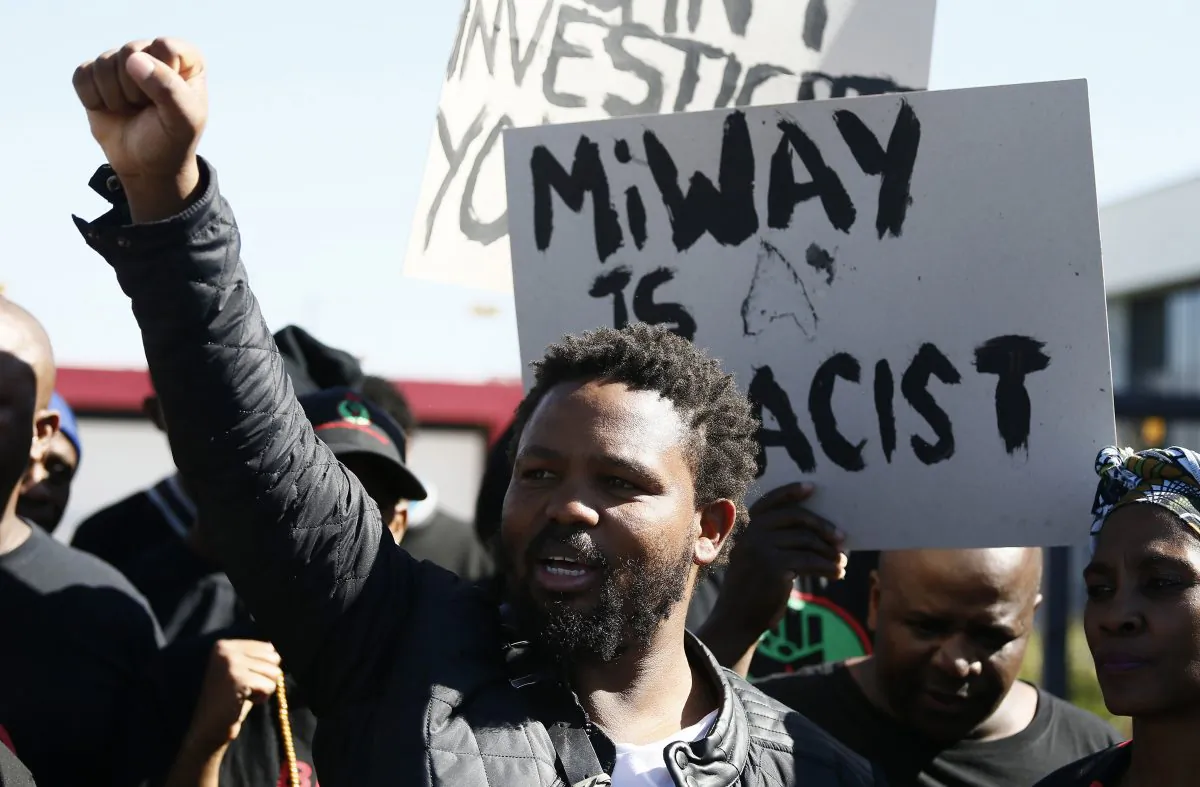 Black First Land First (BLF) leader Andile Mngxitama holds up his fist as BLF members picket outside the offices of MiWay Insurance Company in Centurion on July 21, 2017. (Phill Magakoe/AFP/Getty Images)