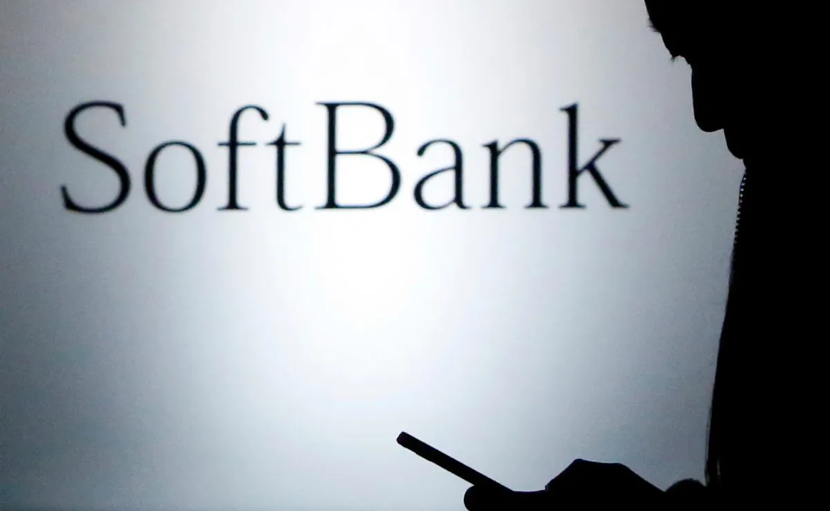 A pedestrian holding a mobile phone walks past a logo of SoftBank Corp in front of its branch in Tokyo on Dec. 31, 2013. (Yuya Shino/Reuters)