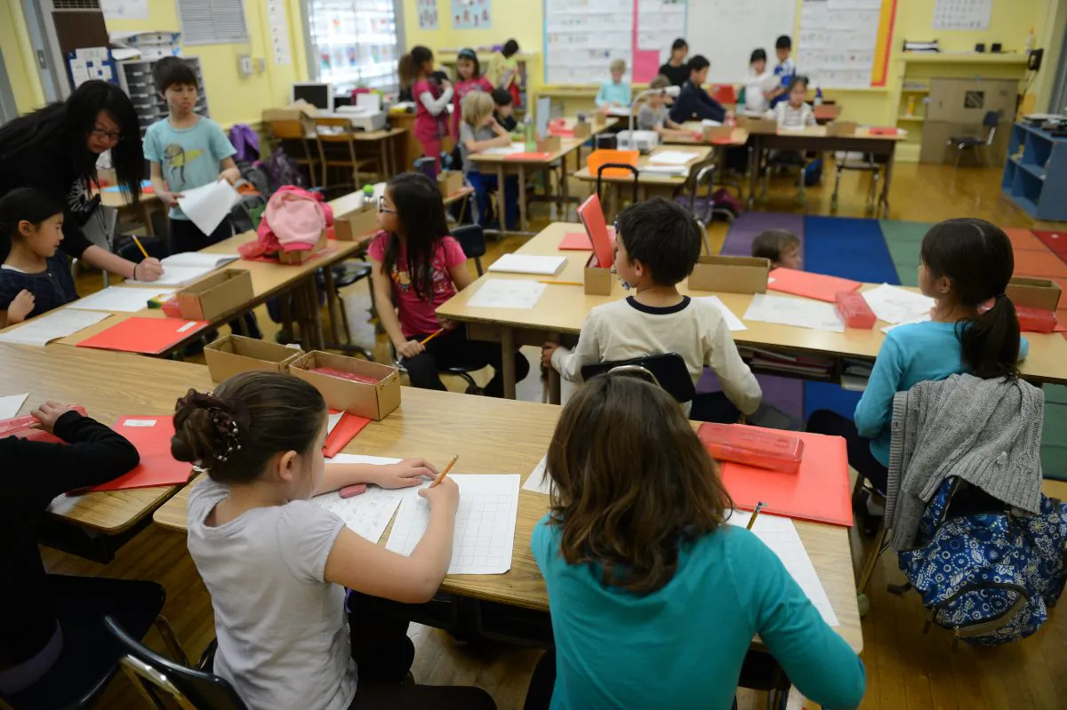 A language immersion teacher, left, checks her students' work during a second-grade class at Broadway Elementary School in Venice, California on Jan. 31, 2013. (Robyn Beck/AFP/Getty Images)