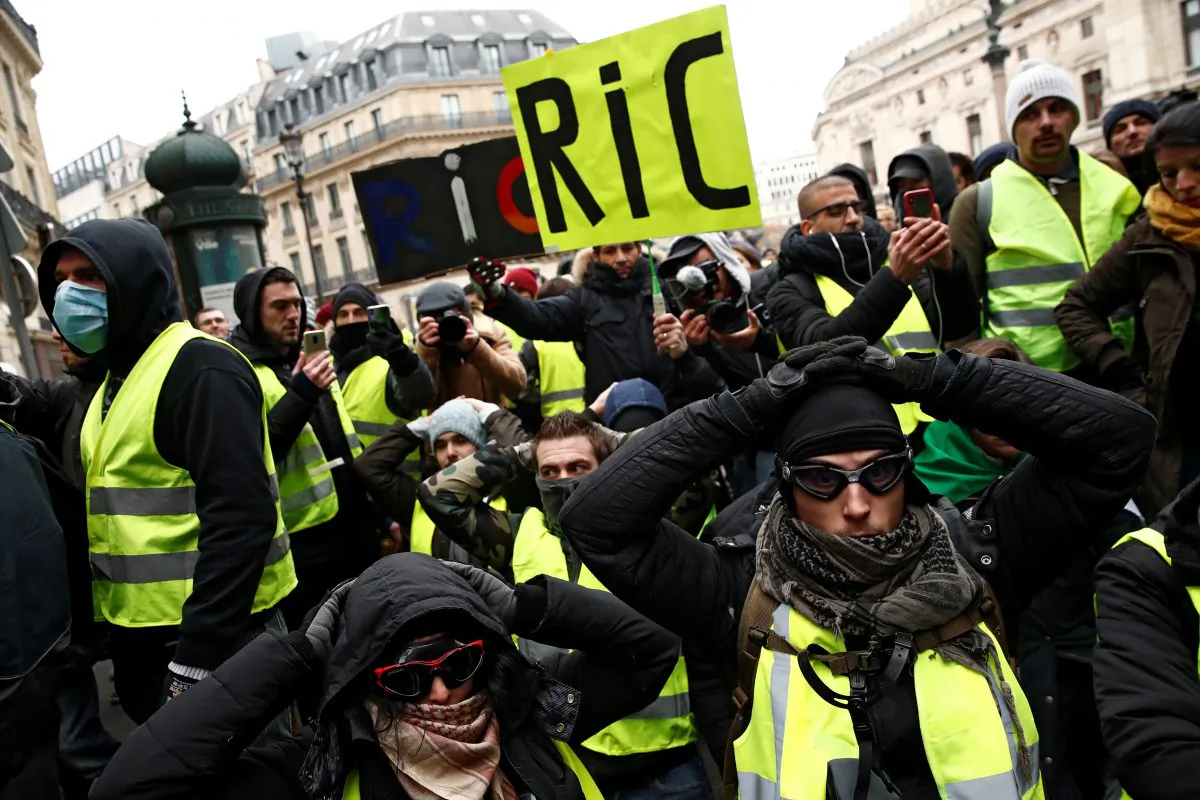 Protesters wearing yellow vests kneel on the street as they gather in front of the Opera House as part of the 'yellow vests' movement in Paris on Dec. 15, 2018. (Reuters/Christian Hartmann)