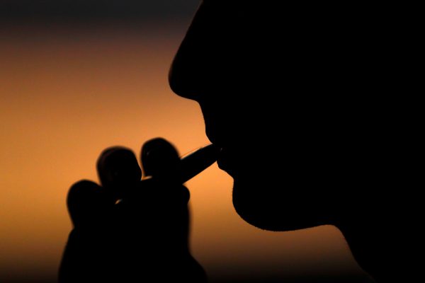 young man smokes electronic cigarette