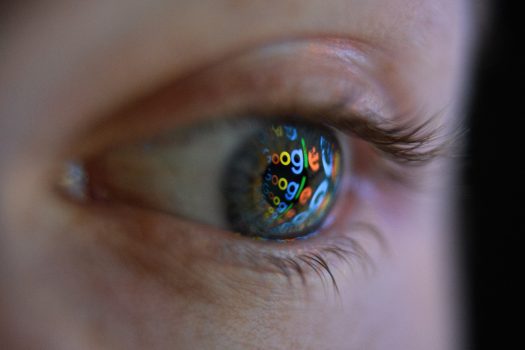 An image of the Google logo is reflected on the eye of a man in London