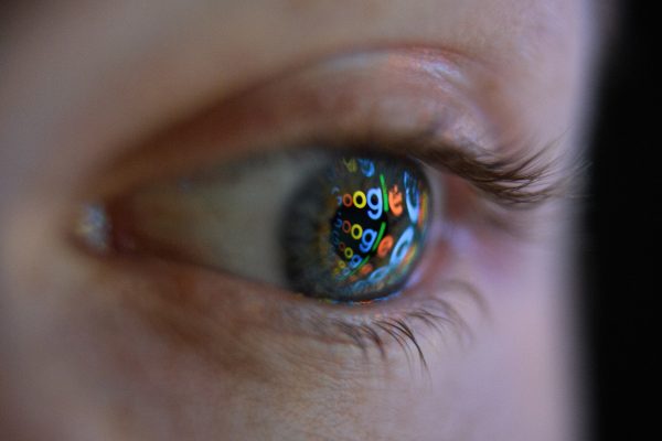 An image of the Google logo is reflected on the eye of a man in London