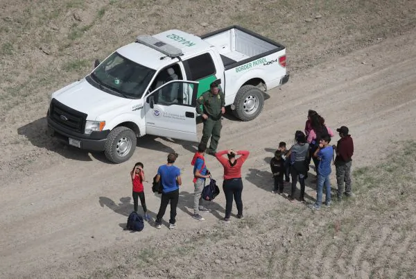 Illegal aliens turn themselves in to a Border Patrol agent after crossing from Mexico into the United States in Mission, Texas, on Nov. 7, 2018. (John Moore/Getty Images)