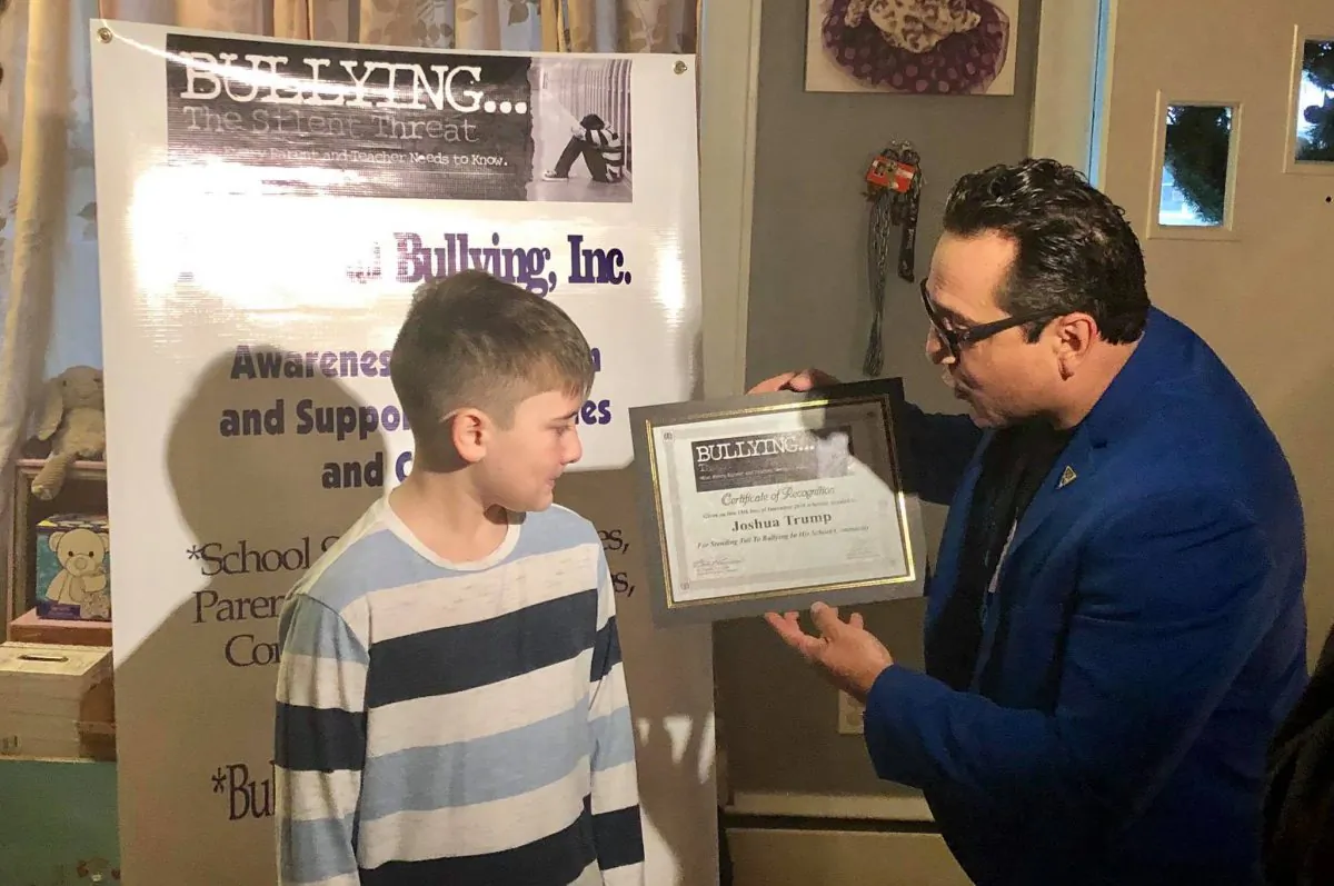 Teach Anti Bullying founder Claudio Cerullo gives an award to Joshua Trump, a Delaware 11-year-old who was bullied for years over his last name, on Dec. 15, 2018. (Teach Anti Bullying)