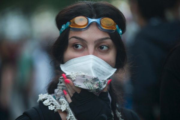A protester covers her face during clashes with Turkish police