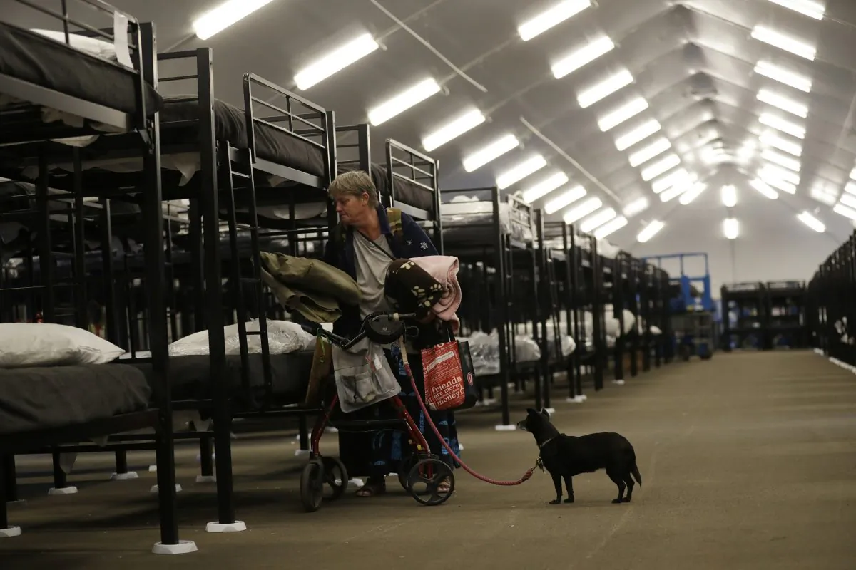 A woman prepares her new bunk in the Temporary Bridge Shelter for the homeless in San Diego on Dec. 1, 2018. (Gregory Bull/AP Photo)