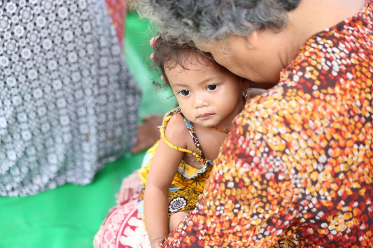 An unidentified woman holding a baby. 
(Cambodian Children’s Trust)
