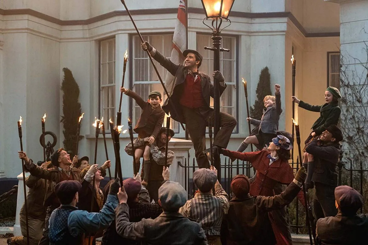 “Mary Poppins Returns” transports audiences back to 1930s London. Lin-Manuel Miranda (center) as a lamplighter. (Walt Disney Productions)