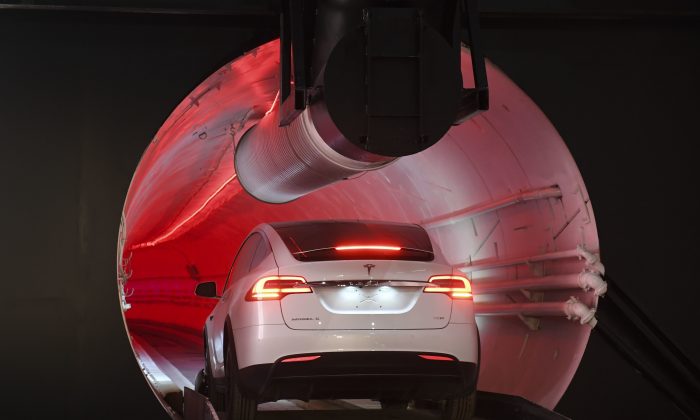 A modified Tesla Model X drives in the tunnel entrance before an unveiling event for the Boring Co. Hawthorne test tunnel in Hawthorne, Calif., on Dec. 18, 2018. (Robyn Beck/Pool Photo/AP)