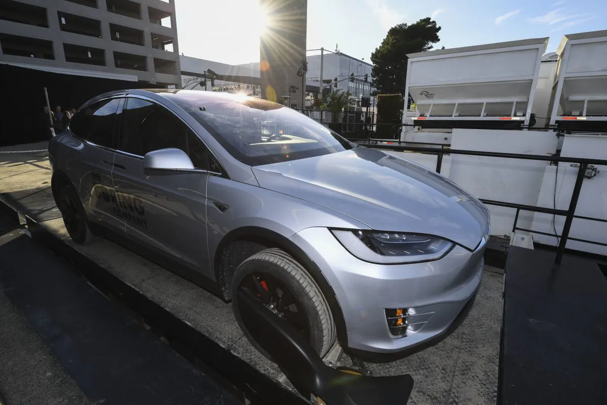 A modified Tesla Model X rests on an elevator above the pit and tunnel entrance before an unveiling event for the Boring Company Hawthorne test tunnel in Hawthorne, Calif., on Dec. 18, 2018. (Robyn Beck/Pool Photo/AP)