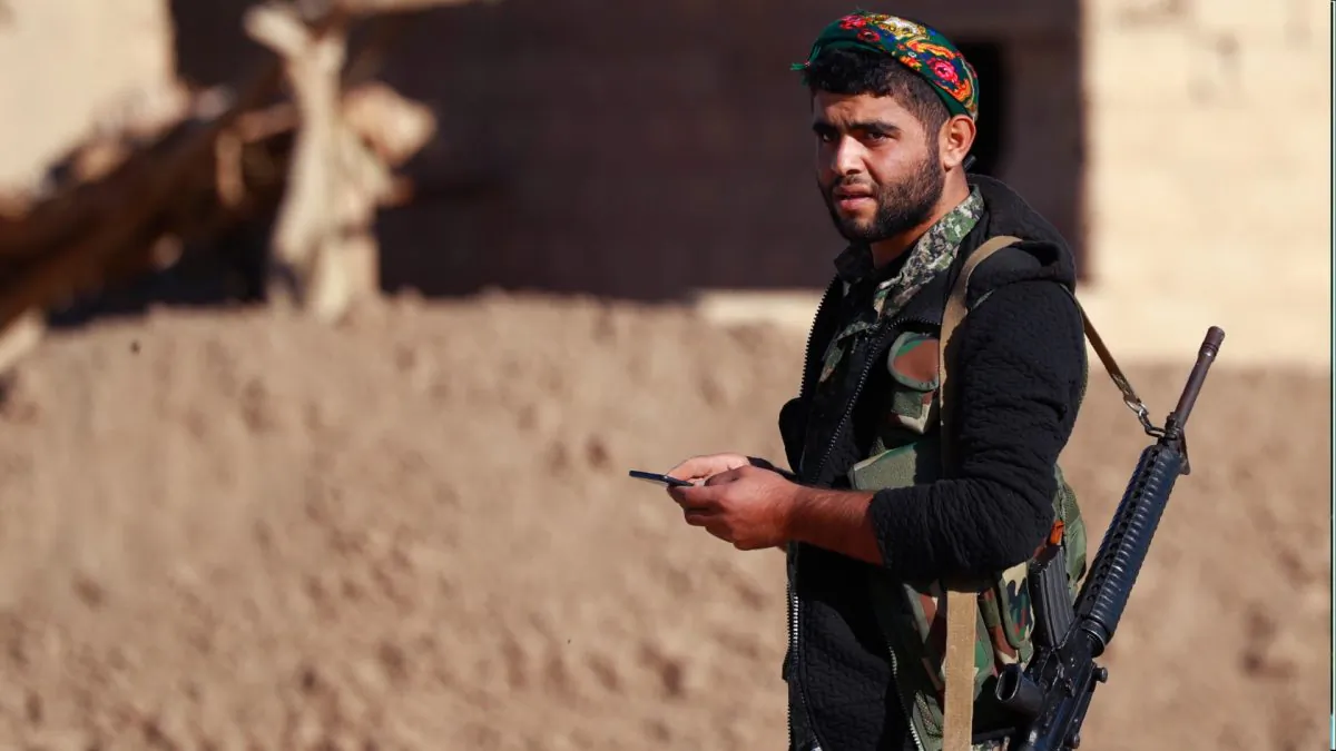 A member of the Syrian Democratic Forces (SDF) holding his rifle in Hajin, in the Deir Ezzor province, eastern Syria, on Dec. 15, 2018. (Delil Souleiman/AFP/Getty Images)