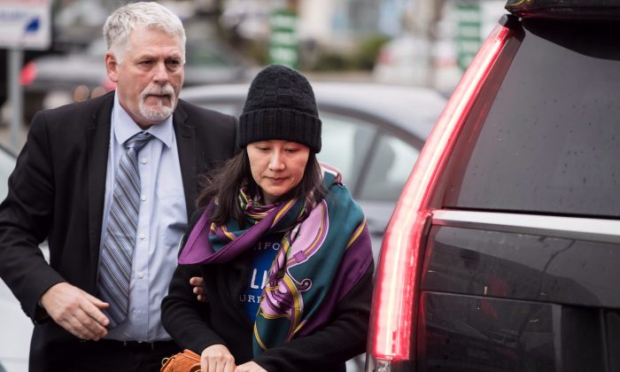 Huawei chief financial officer Meng Wanzhou arrives at a parole office with a member of her private security detail in Vancouver, on Dec. 12, 2018. (The Canadian Press/Darryl Dyck)
