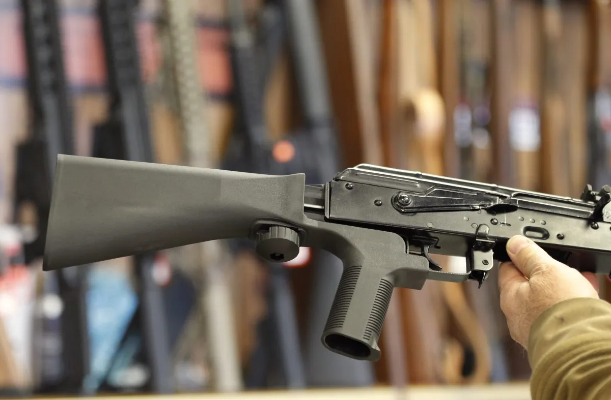 A bump stock device, (left) that fits on a semi-automatic rifle to increase the firing speed, making it similar to a fully automatic rifle, is installed on a AK-47 semi-automatic rifle, (right) at a gun store on Oct. 5, 2017, in Salt Lake City, Utah. The Trump administration has just announced a reversal to a rule that allowed the sale of bump stocks. (George Frey/Getty Images)