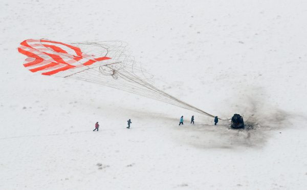 A search and rescue team approaches the Soyuz MS-09 capsule
